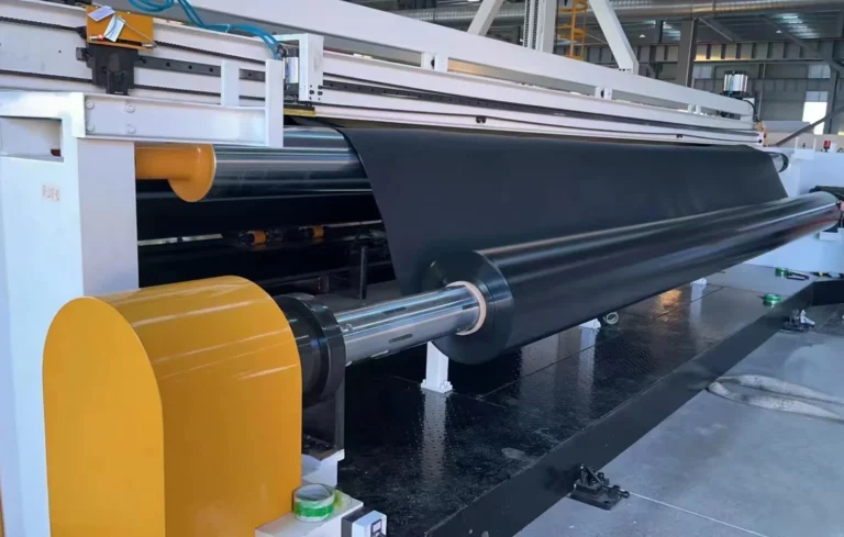 Black geomembrane sheet passing through rollers on the Jinseed production line
