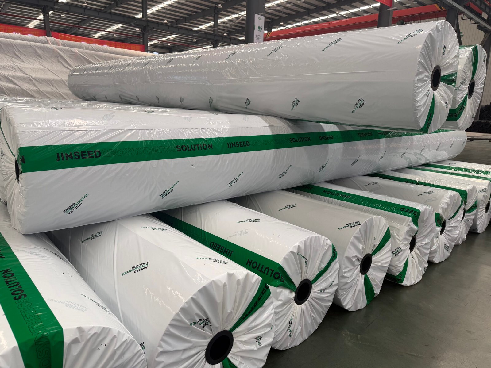 Side view of packaged geotextile rolls inside the Jinseed factory