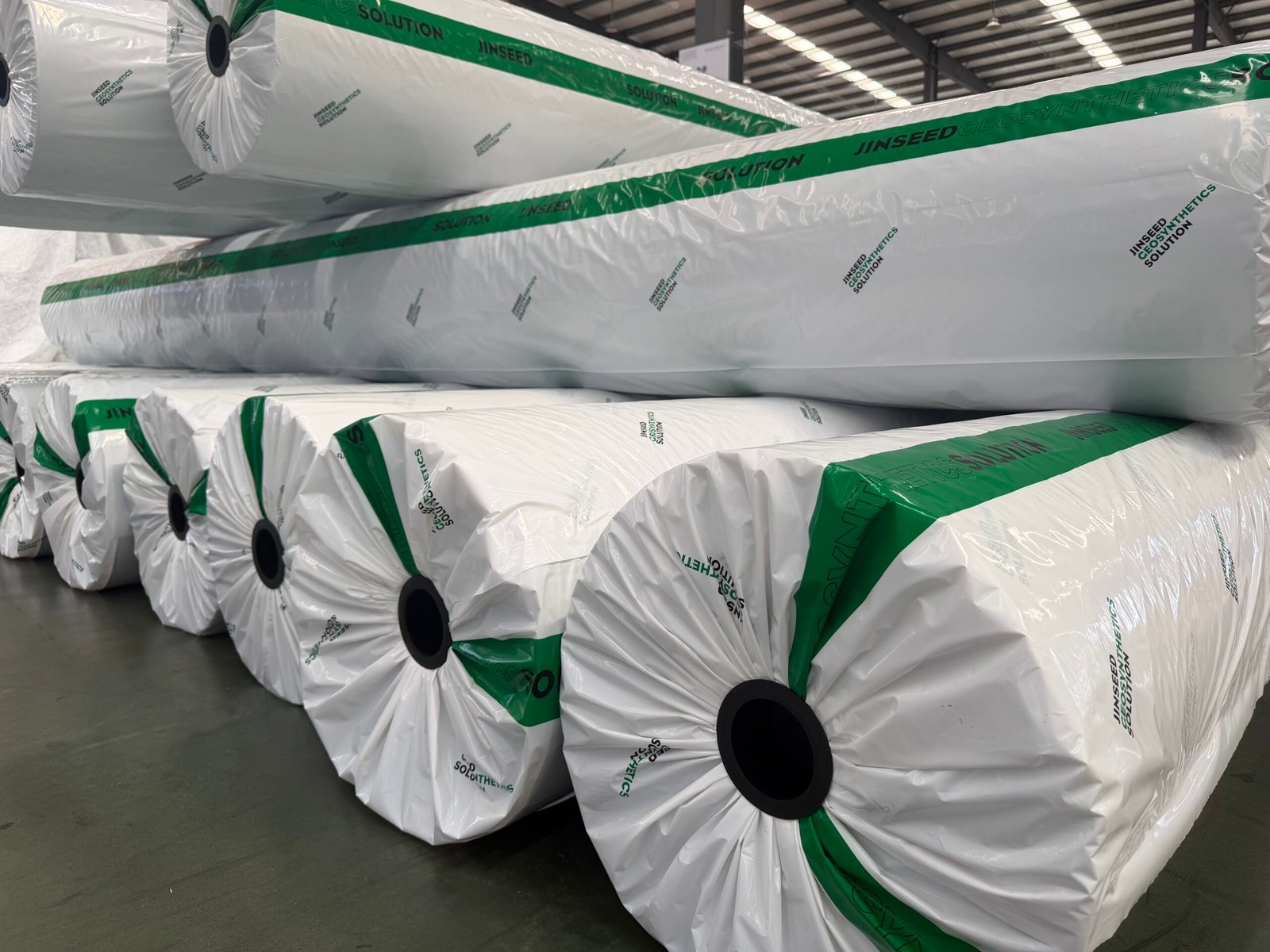 Close view of wrapped geotextile rolls with Jinseed green and white packaging