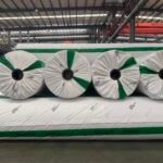 Jinseed-branded wrapped geotextile rolls viewed from the roll ends in the factory
