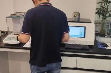 Technician working at a laboratory bench with a balance and testing equipment