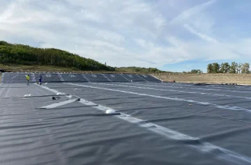 Geomembrane panels with field markings across a lined basin during installation